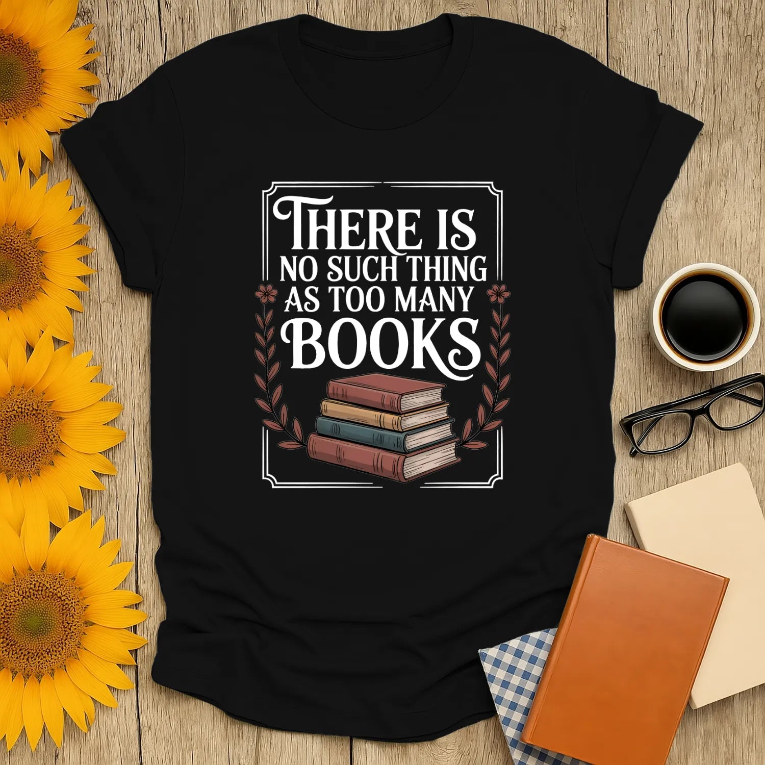 A cozy black t-shirt with the funny quote "There is no such thing as too many books" over stacked vintage books, perfect for book lovers.