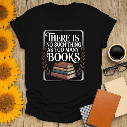 A cozy black t-shirt with the funny quote "There is no such thing as too many books" over stacked vintage books, perfect for book lovers.