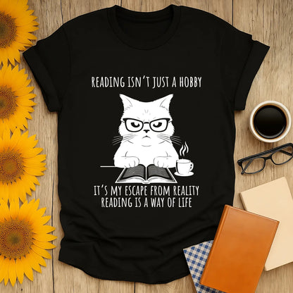 Funny bookworm t-shirt featuring a grumpy cat in glasses with the text: "Reading isn’t just a hobby, it’s my escape from reality"