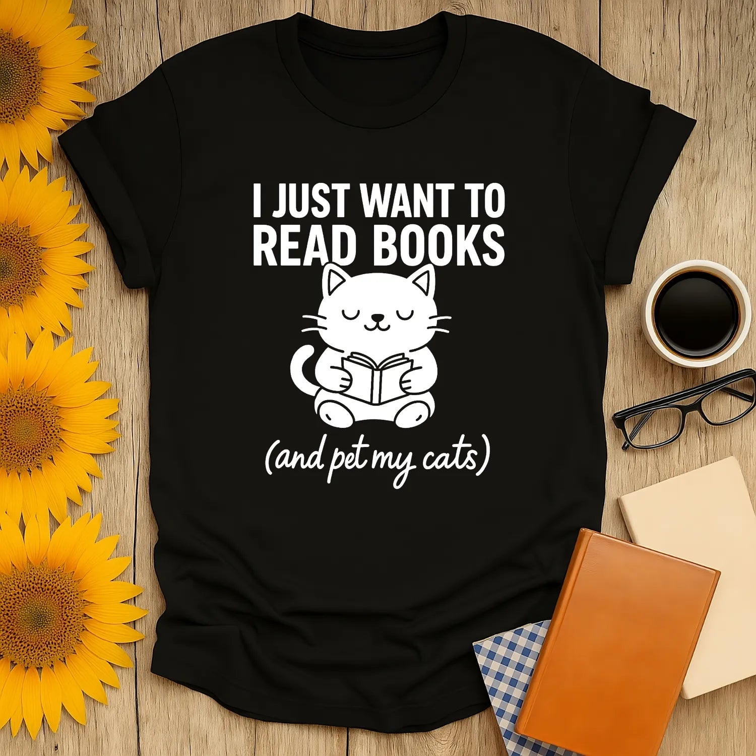 Cozy black t-shirt featuring a cute cat reading, with the text 'I Just Want to Read Books (and pet my cats)' for book lovers.