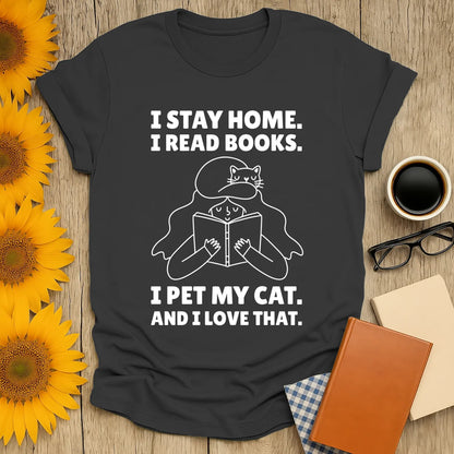 Cozy book lover shirt featuring text: 'I stay home. I read books. I pet my cat. And I love that.' Perfect gift for cat and book enthusiasts!
