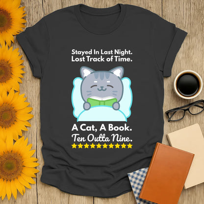 Cozy book lover shirt featuring a cute cat reading with text: "Stayed In Last Night. A Cat, A Book. Ten Outta Nine." Perfect gift for bookworms!
