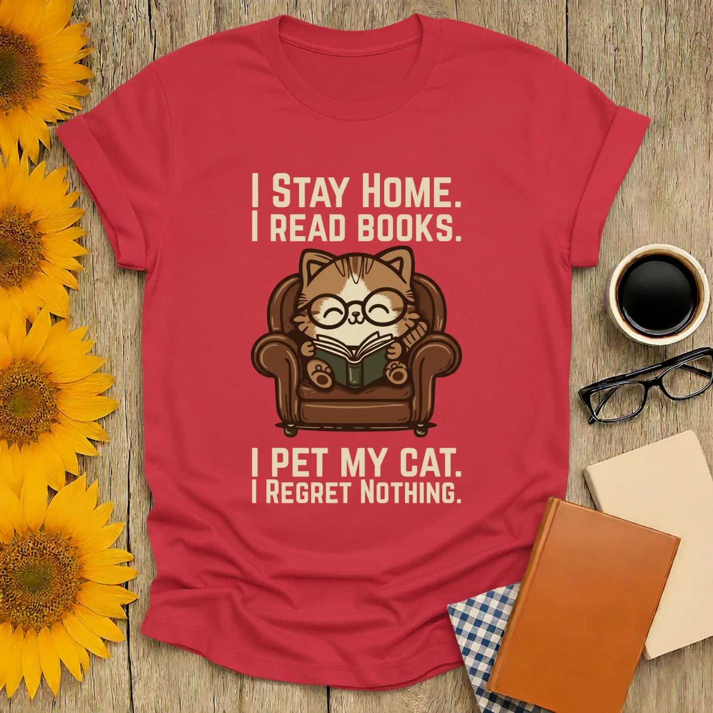 Armchair Cat Reader T-Shirt featuring a cozy cat in glasses reading, with humorous text about staying home and loving cats.