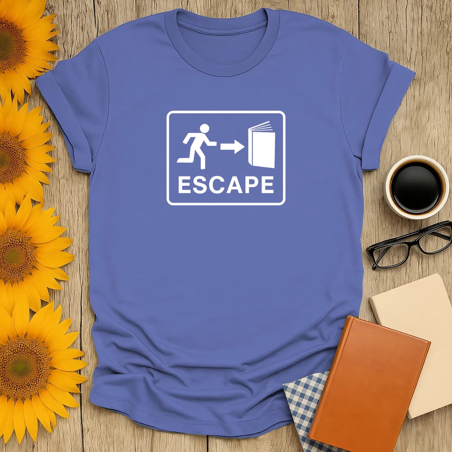 Light blue t-shirt featuring 'Escape' graphic with a person running towards a book, perfect for book lovers and cozy reading.