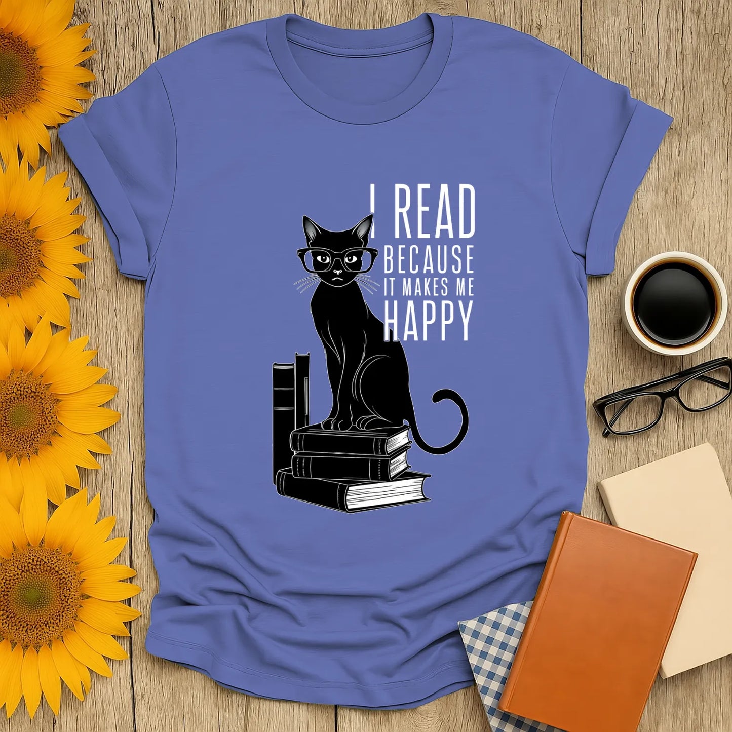 Light blue unisex t-shirt featuring a happy black cat in glasses, with text: 'I READ BECAUSE IT MAKES ME HAPPY'.
