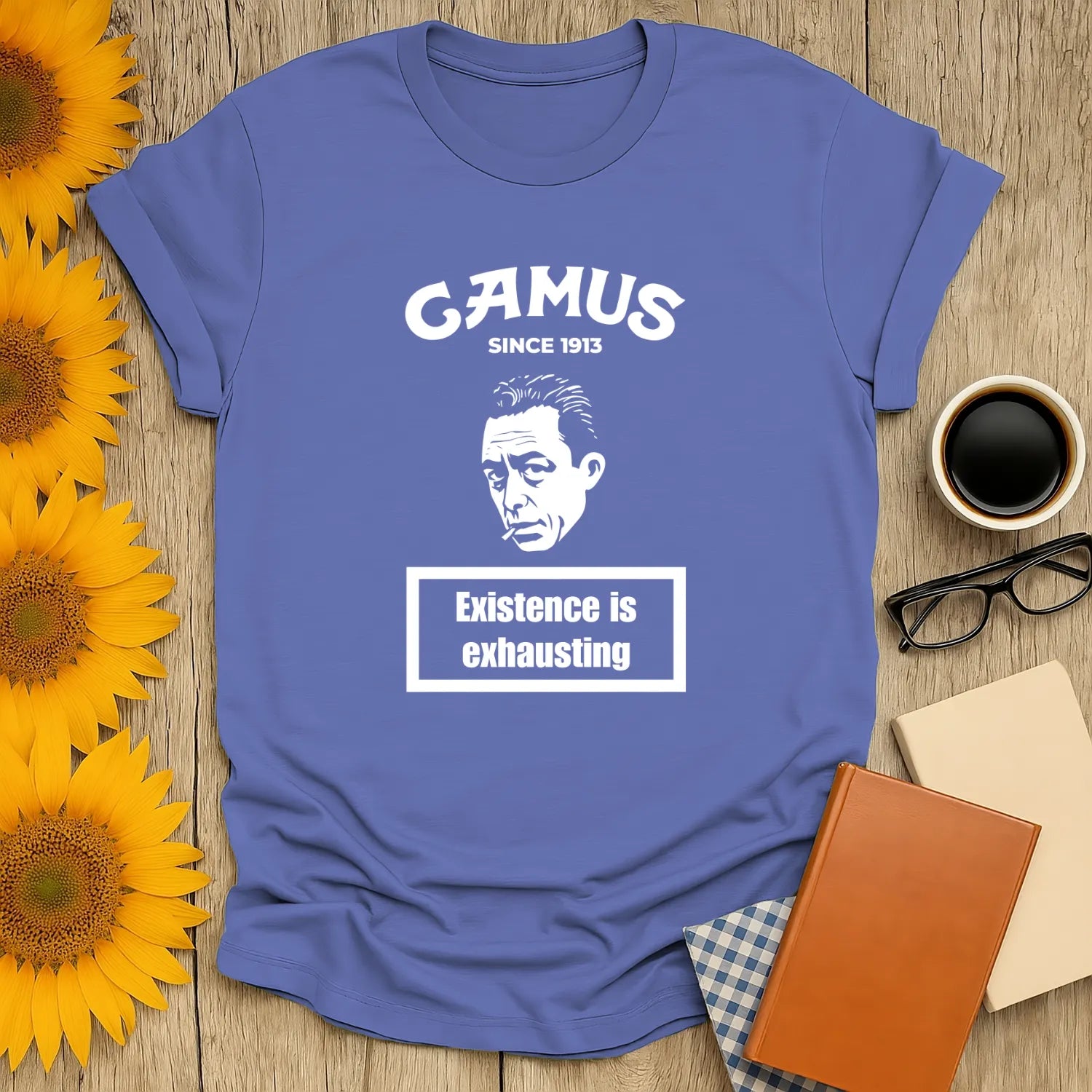 Blue Camus t-shirt featuring a contemplative face and text 'Existence is exhausting'—perfect for book lovers and cozy vibes.