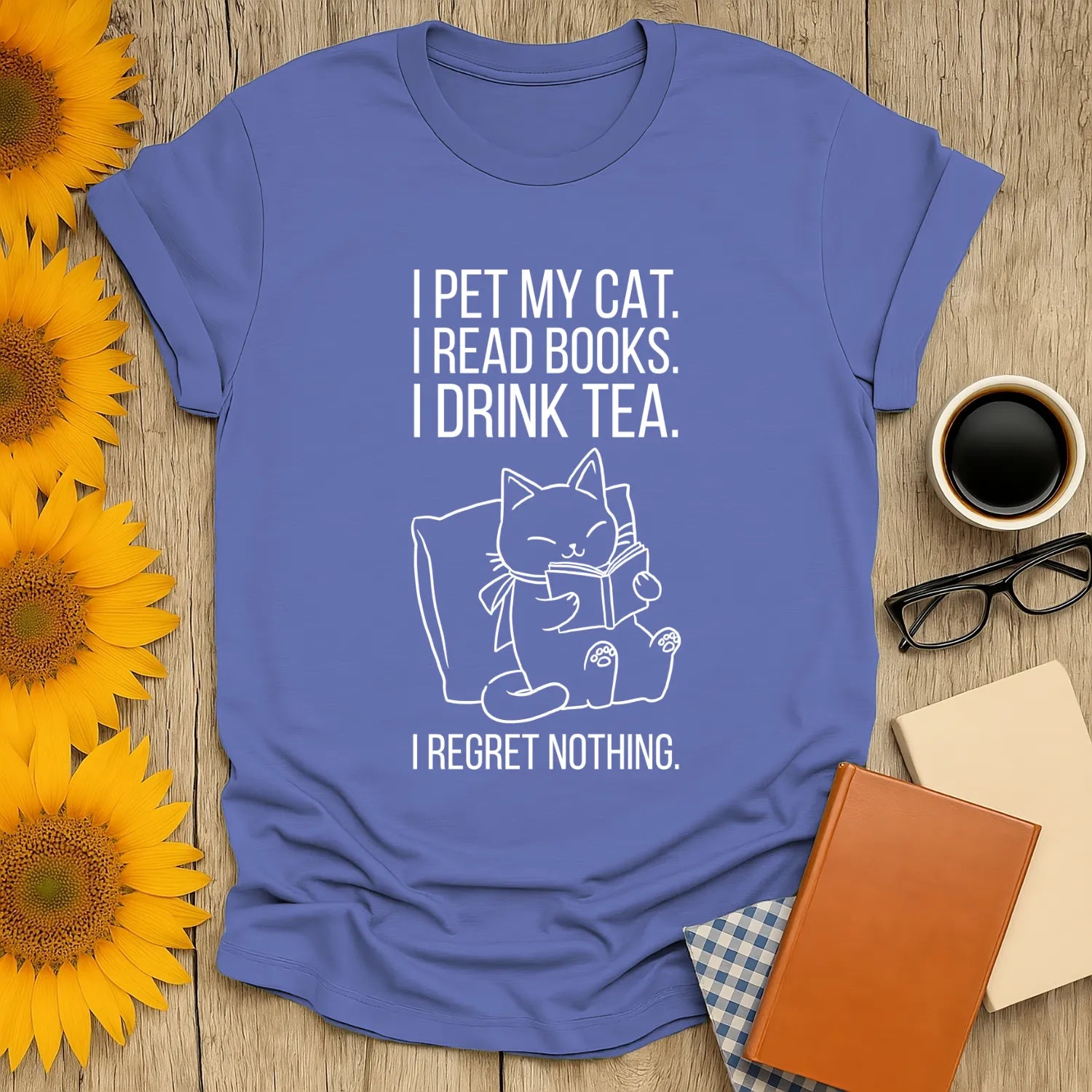 Cozy blue t-shirt with a playful cat illustration and text: "I pet my cat. I read books. I drink tea. I regret nothing." Perfect for book lovers.