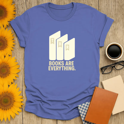 A cozy blue t-shirt featuring minimalist stacked books and the text 'BOOKS ARE EVERYTHING.' Perfect for book lovers and gifts.