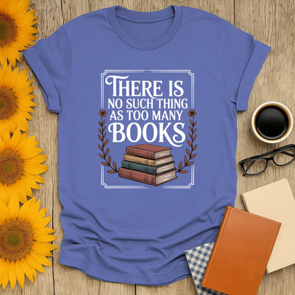 Funny reading tee featuring stacked books and text 'There is no such thing as too many books' perfect for cozy book lovers.