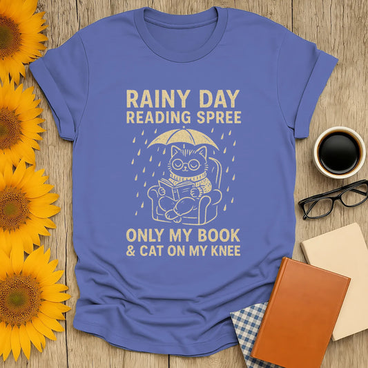 Funny Rainy Day Reading Spree T-shirt featuring a cat with a book under an umbrella, perfect for book lovers and cozy vibes.