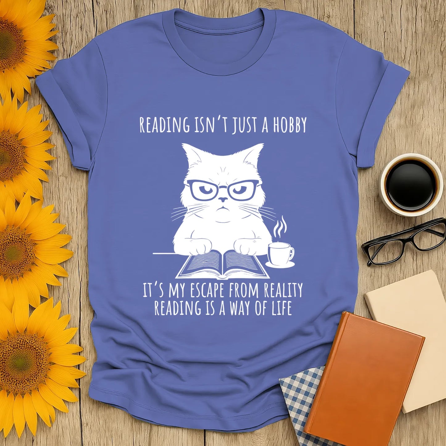 Cozy book lover t-shirt featuring a grumpy cat with glasses, book, and coffee, perfect for readers who enjoy bookish humor.