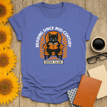 Cat reading a book in a cozy armchair with the text 'Reading Since Mid-Century Book Club' on a blue tee, perfect gift for book lovers.