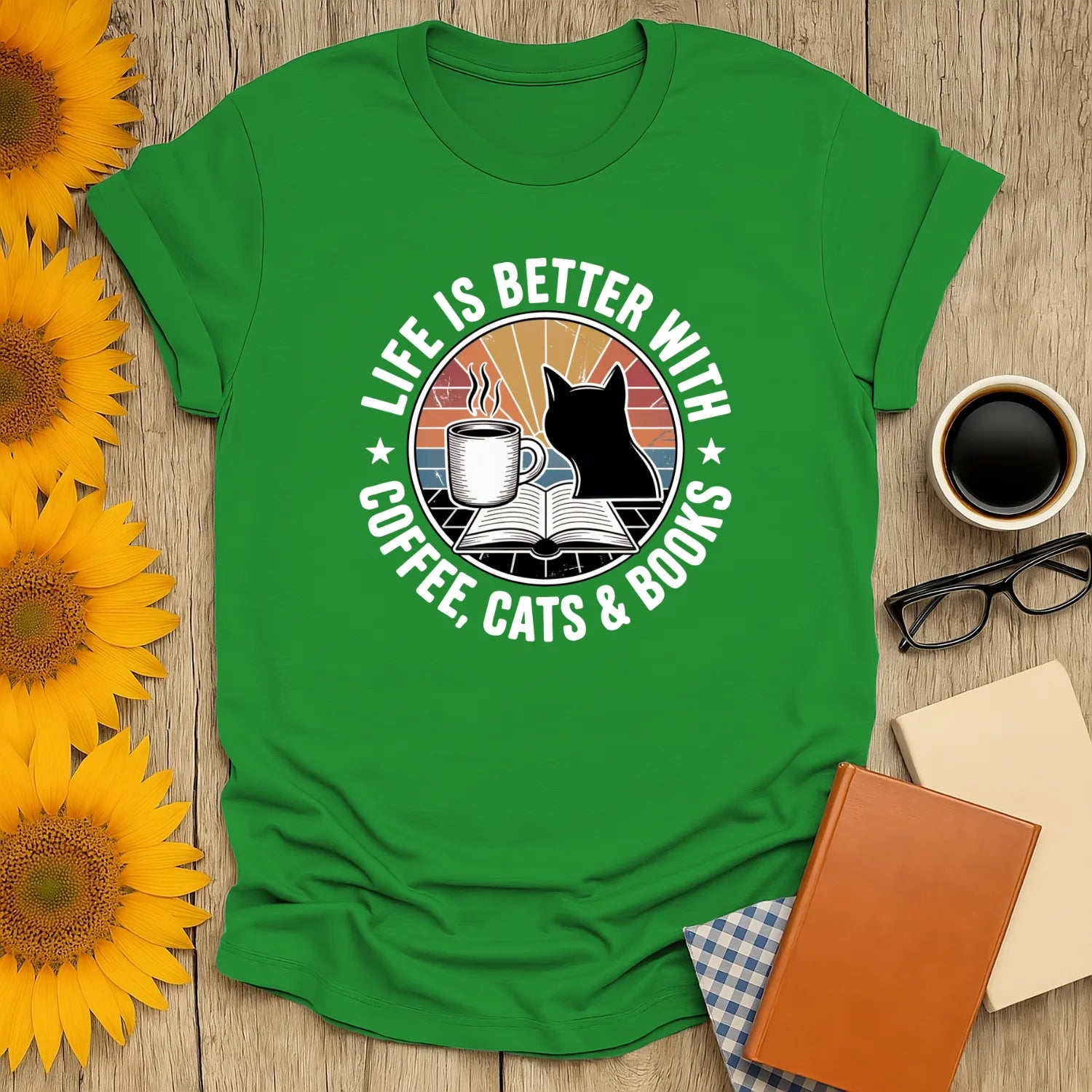 Green tee with a cat and coffee illustration, saying 'Life is better with coffee, cats & books'. Perfect gift for book lovers.