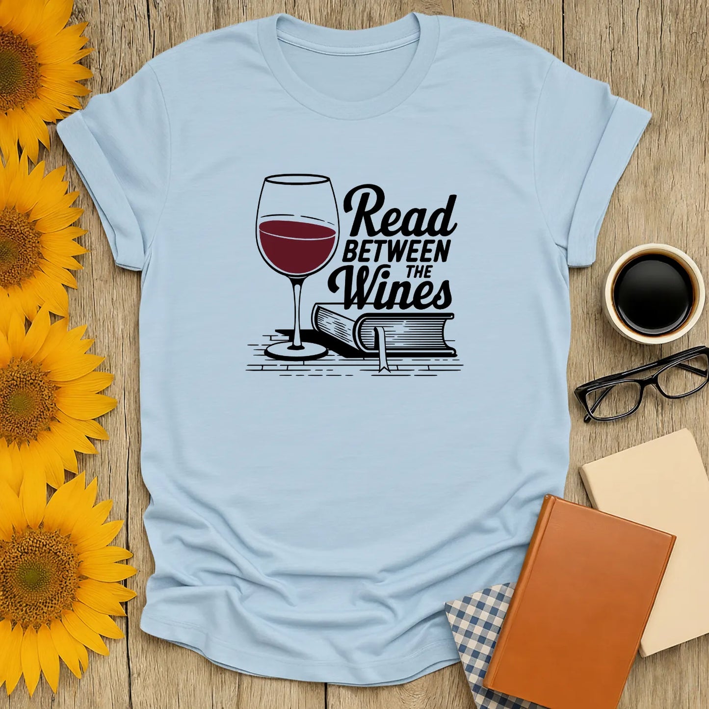 Read Between the Wines T-Shirt featuring a wine glass and book illustration, cozy relaxed fit, perfect gift for readers 📖.