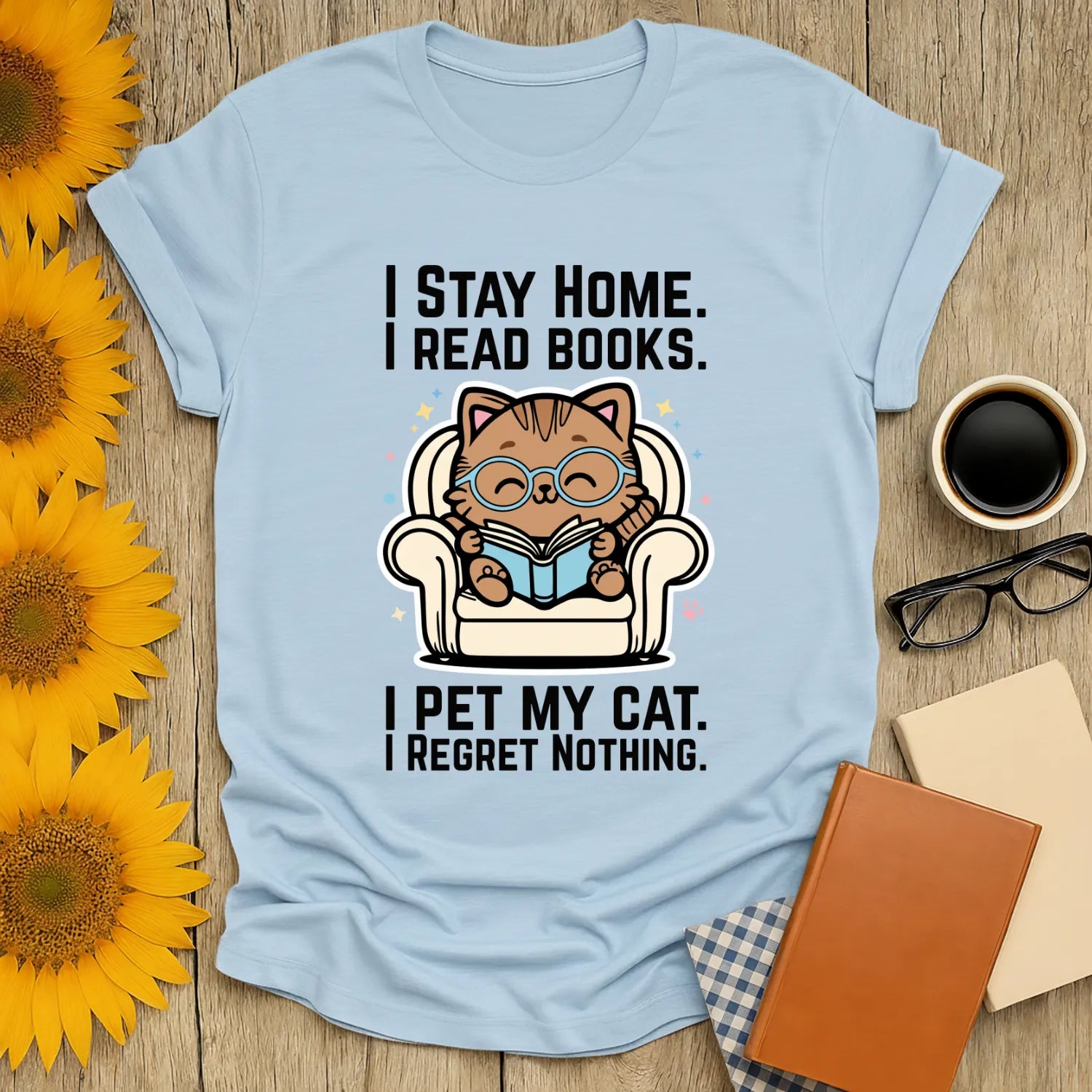 Starry Cat Reader T-Shirt featuring a whimsical cat in glasses reading on a couch, surrounded by stars. Perfect gift for book lovers.