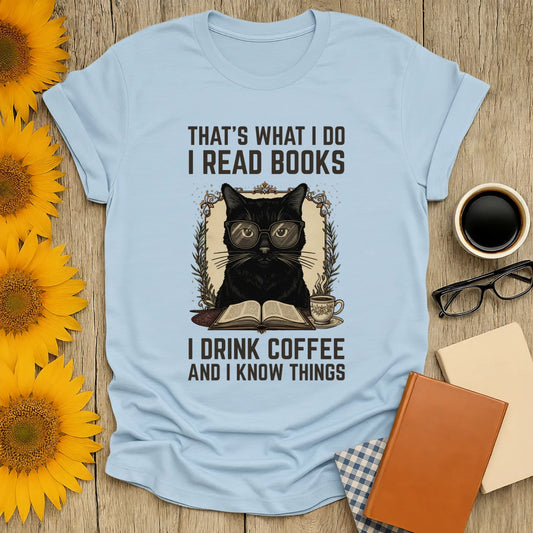 Coffee Cat Reader T-Shirt featuring a black cat in glasses, sipping coffee, reading a book, and saying funny literary quotes.