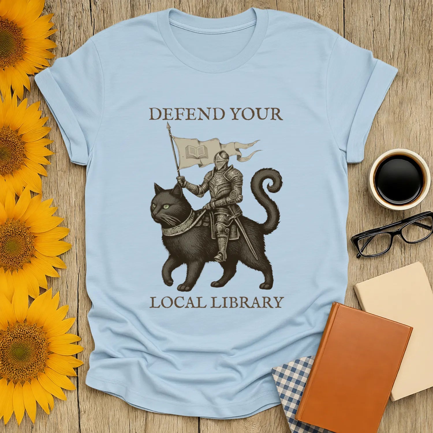 Library Defender T-Shirt with a knight on a cat, promoting bookish humor for cozy readers. Perfect for book lovers!