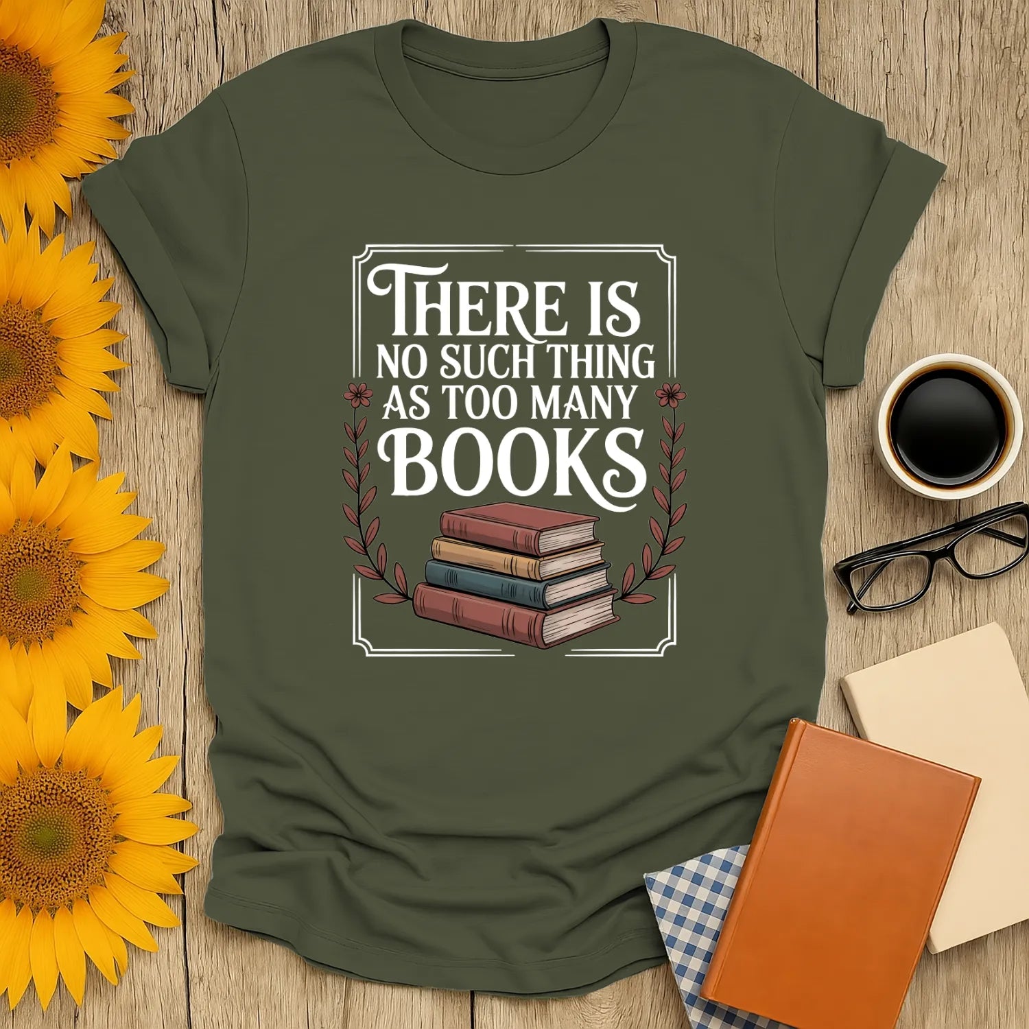 Cozy green tee with illustration of stacked books & text: 'There is no such thing as too many books.' Perfect gift for book lovers!