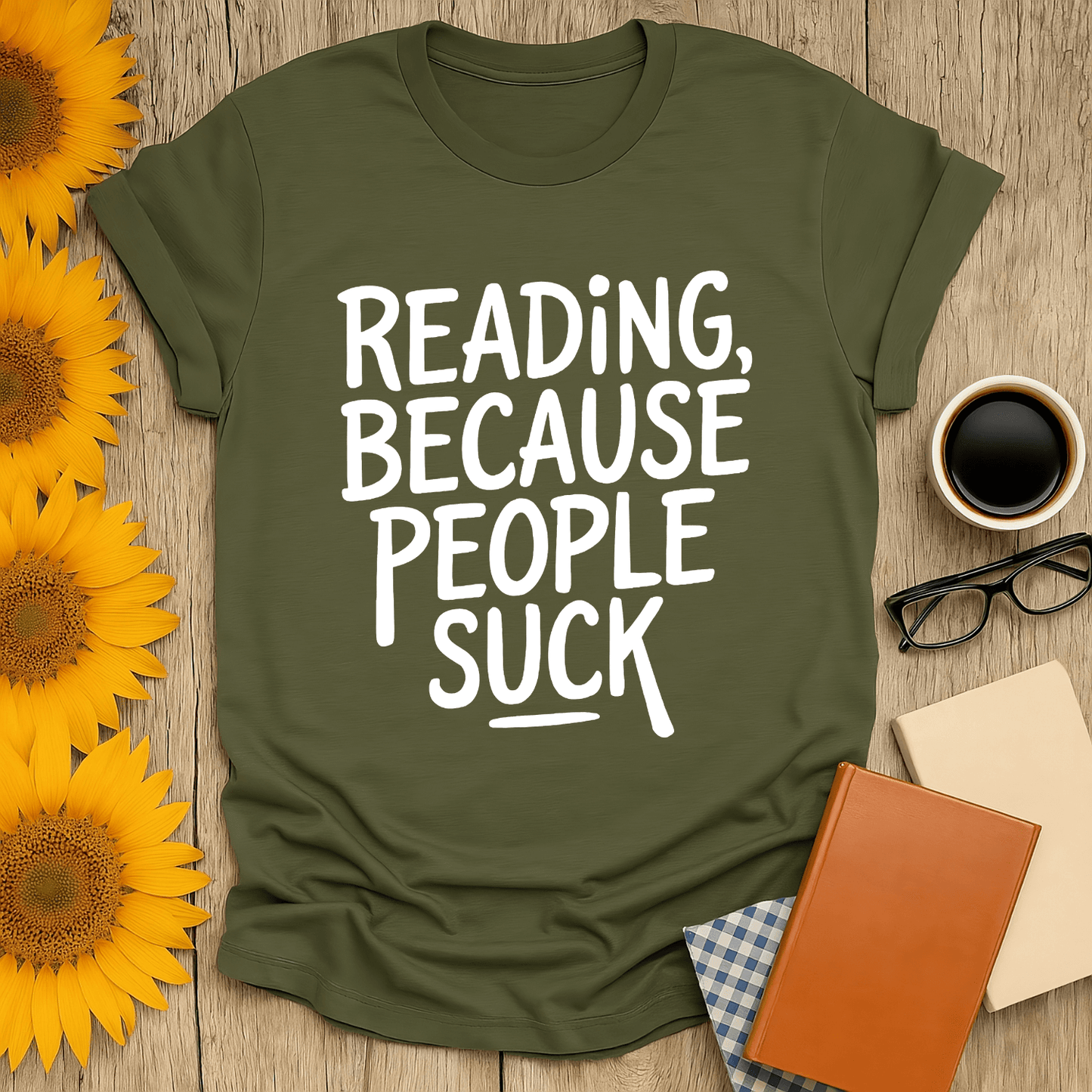 Unisex book lover t-shirt in olive green with "Reading, Because People Suck" printed design, styled with sunflowers and a coffee.