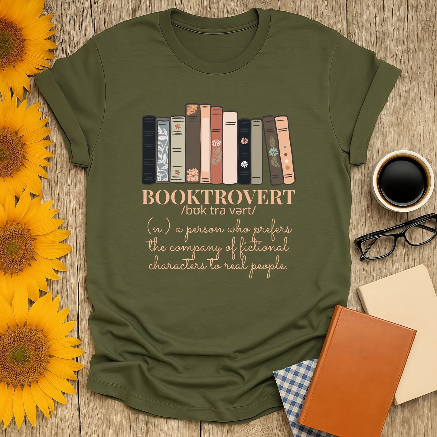 Booktrovert t-shirt featuring colorful book spines and a witty definition, perfect for cozy moments and gifts for readers.