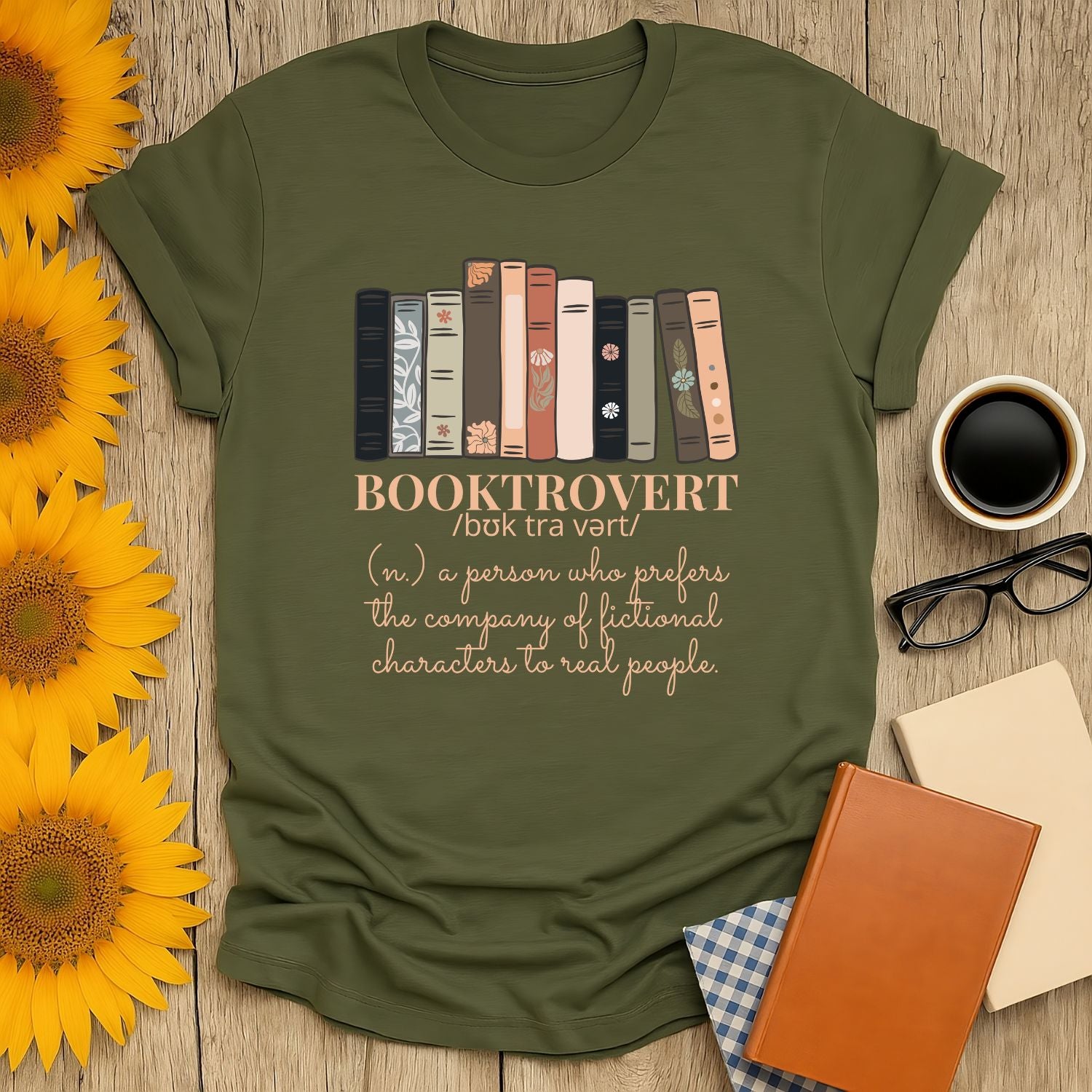 Booktrovert t-shirt featuring colorful book spines and a witty definition, perfect for cozy moments and gifts for readers.