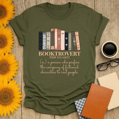 Booktrovert t-shirt featuring colorful book spines and a witty definition, perfect for cozy moments and gifts for readers.