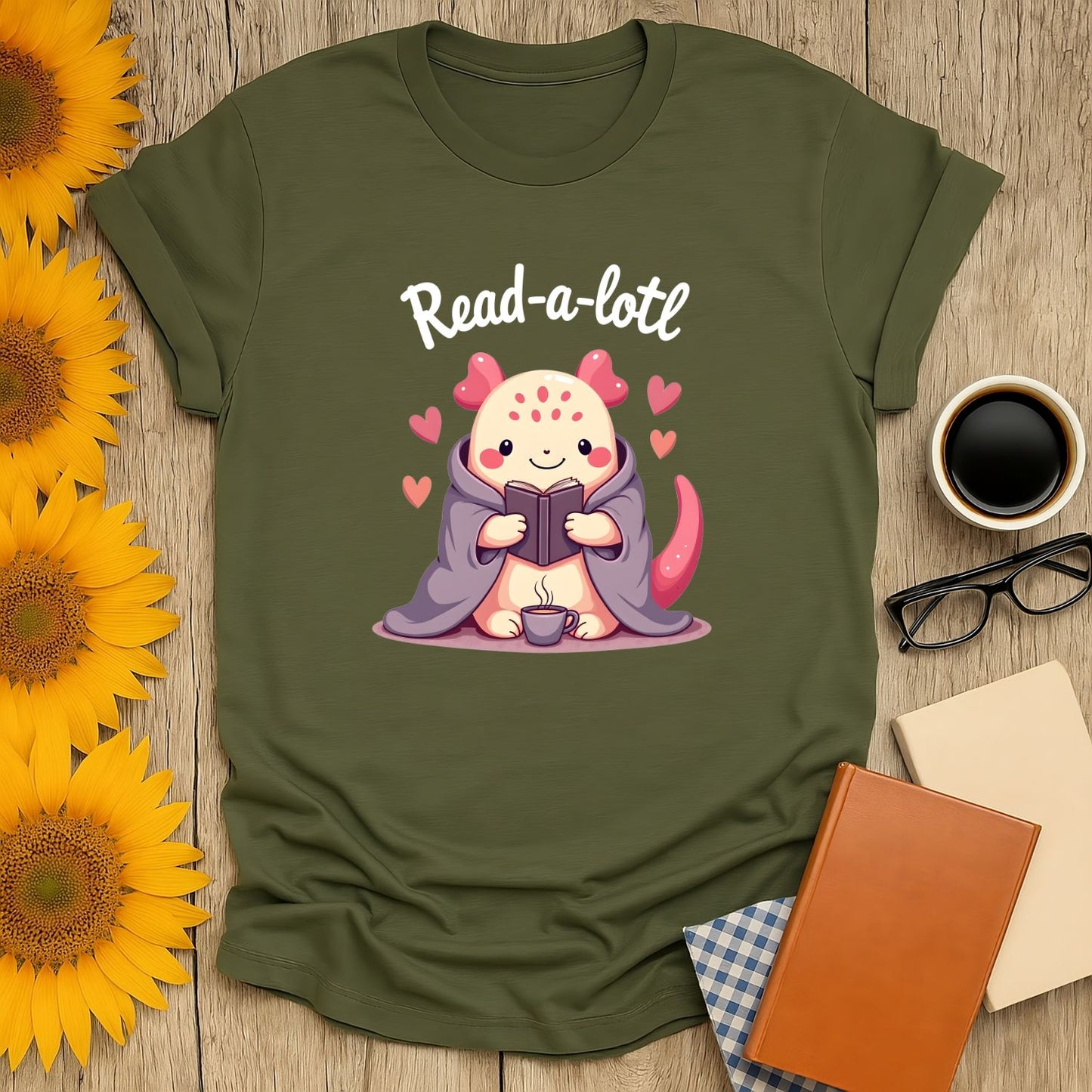 Cute illustration of a cozy creature reading with the text 'Read-a-lotl'—perfect book lover shirt for cat or tea fans!
