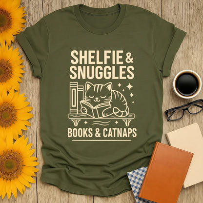 Warm olive tee featuring a sleeping cat reading, with 'Shelfie & Snuggles' text—perfect for book lovers and cat enthusiasts.