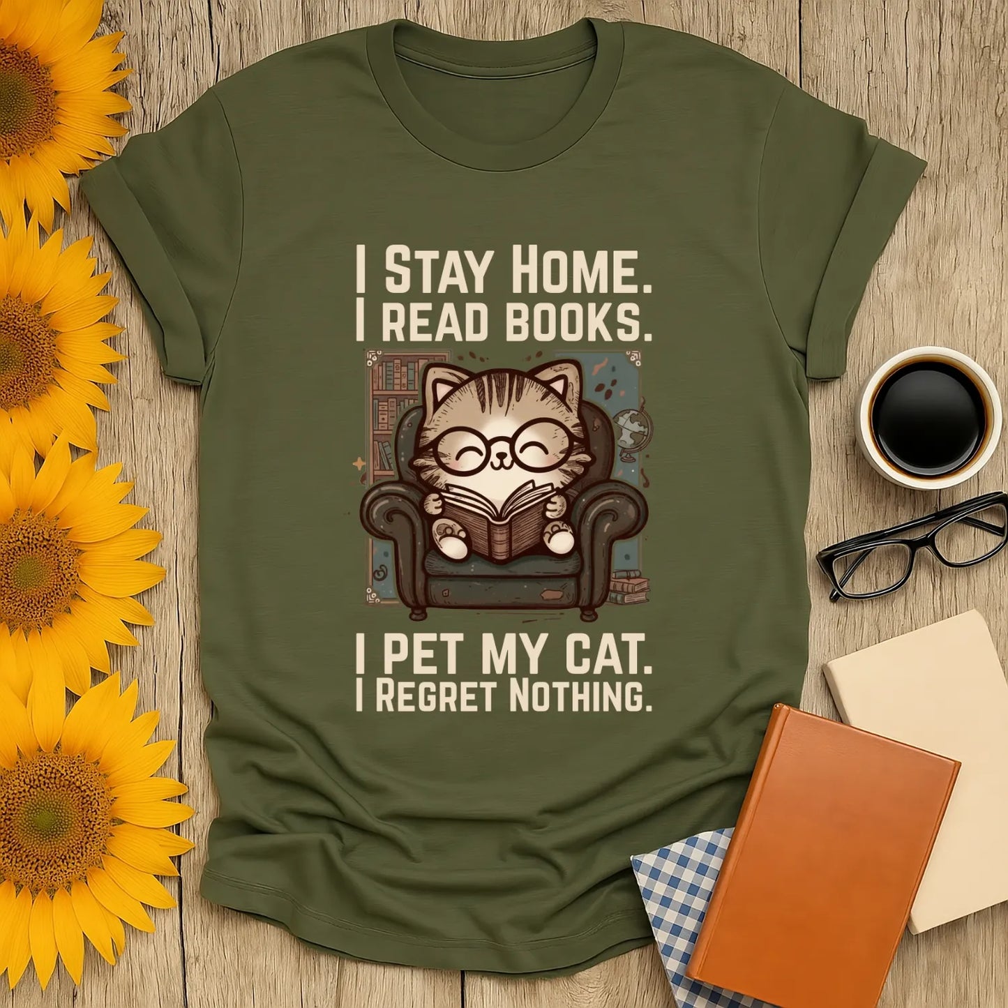 Library Cat Reader T-Shirt featuring a cozy cat in glasses, reading a book in an armchair with the text: 'I Stay Home. I Read Books. I Pet My Cat. I Regret Nothing.' Perfect for book lovers and cat enthusiasts.