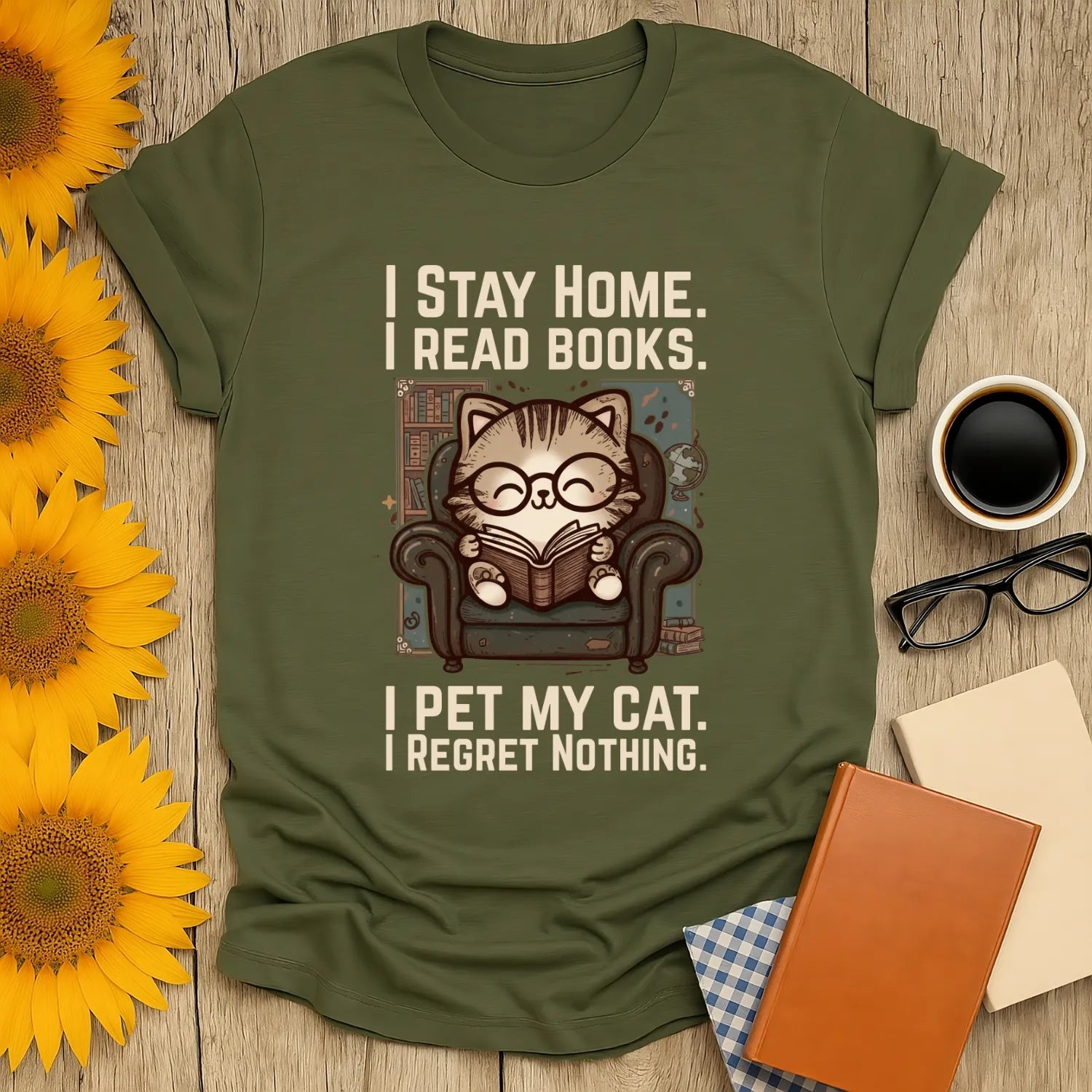 Library Cat Reader T-Shirt featuring a cozy cat in glasses, reading a book in an armchair with the text: 'I Stay Home. I Read Books. I Pet My Cat. I Regret Nothing.' Perfect for book lovers and cat enthusiasts.