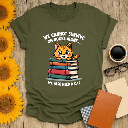 Cozy book lover t-shirt featuring a cute cat on stacked books with text: 'We cannot survive on books alone... We also need a cat.'