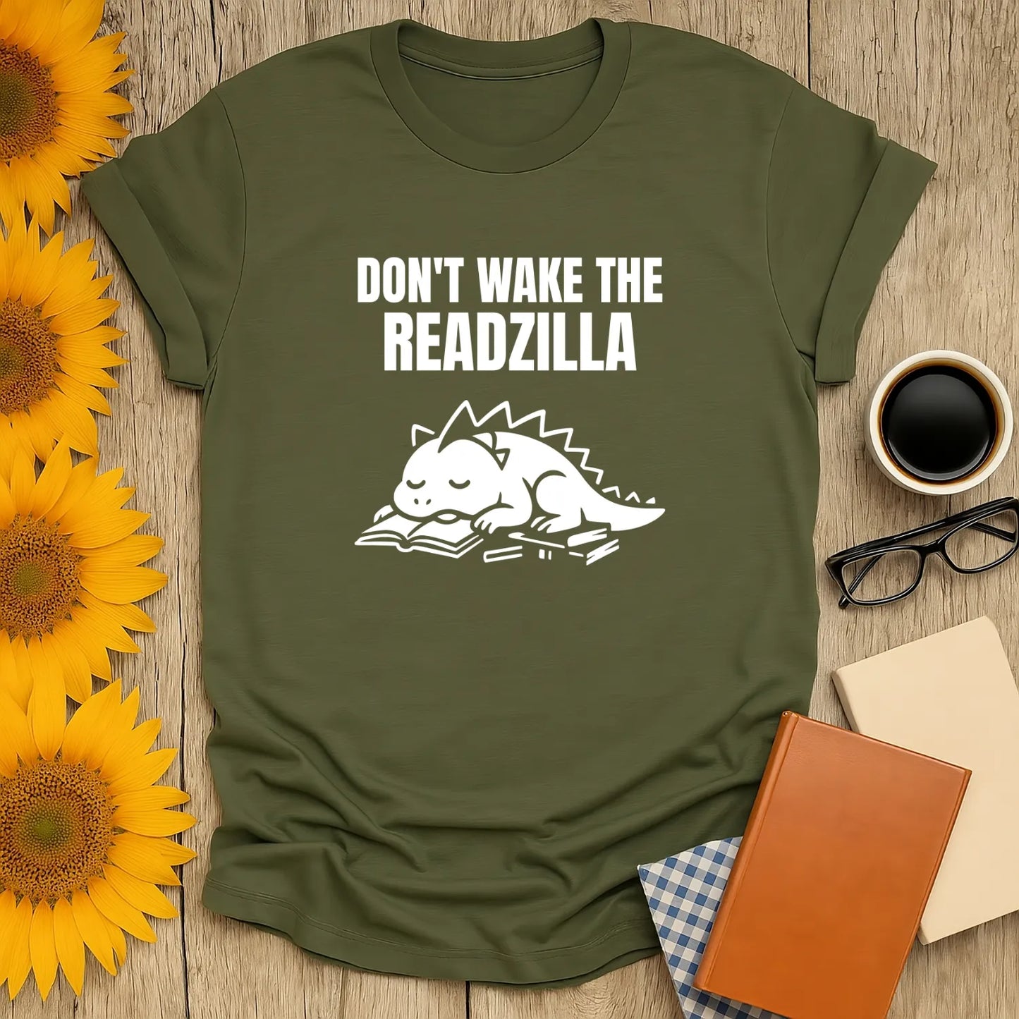 Funny green t-shirt featuring a cute dragon napping on a book with the text 'Don't Wake the Readzilla' – a cozy shirt for book lovers.