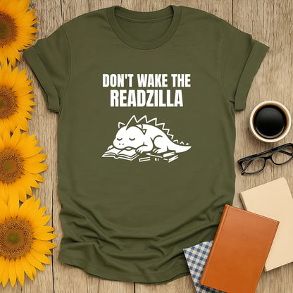 Funny green t-shirt featuring a cute dragon napping on a book with the text 'Don't Wake the Readzilla' – a cozy shirt for book lovers.