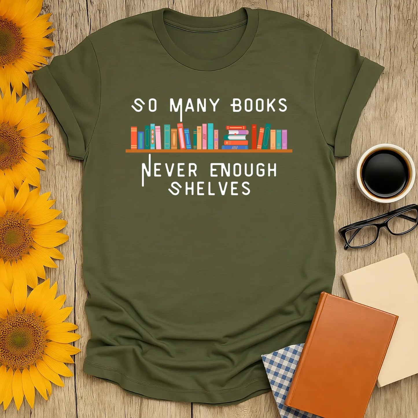 Soft olive green t-shirt with "So Many Books, Never Enough Shelves" text, perfect for book lovers who adore coffee and cozy vibes.