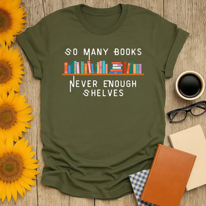 Soft olive green t-shirt with "So Many Books, Never Enough Shelves" text, perfect for book lovers who adore coffee and cozy vibes.