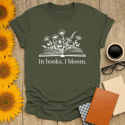 Cozy book lover shirt with an open book and flowers, saying 'In books, I bloom.' Perfect gift for readers who enjoy cats, coffee, or tea.