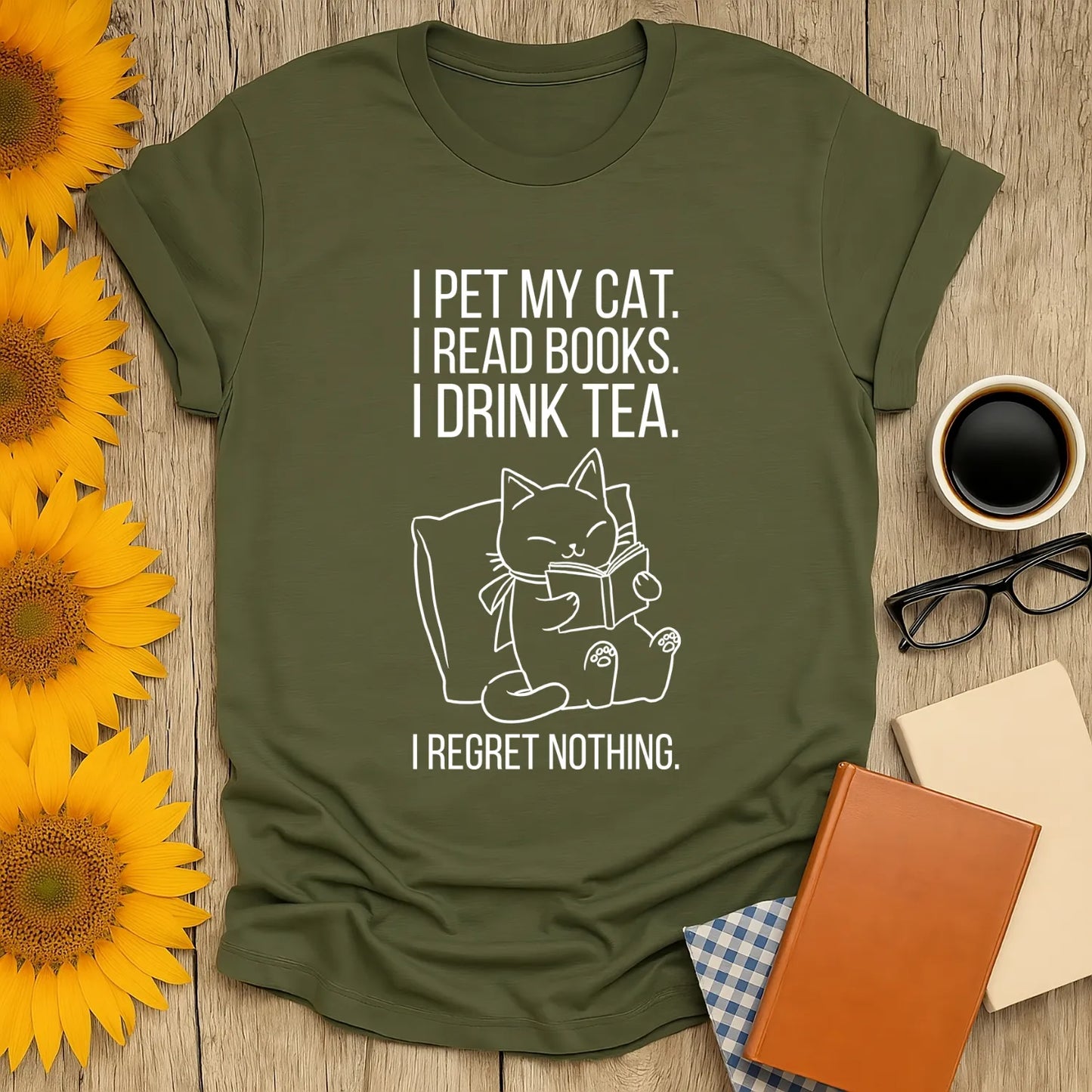 A cozy green t-shirt featuring a cat illustration with text: 'I pet my cat. I read books. I drink tea. I regret nothing.' Perfect for book lovers!