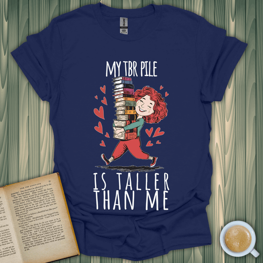 TBR Tower T-Shirt featuring cute character with stacked books, perfect for book lovers and cozy reading vibes.