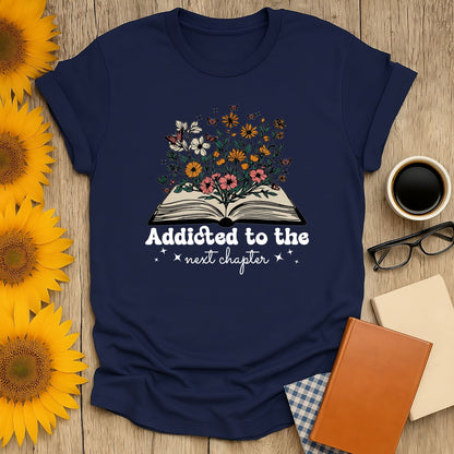 Navy blue 'Addicted to the next chapter' shirt with floral book illustration, perfect gift for cat and coffee-loving bookworms.