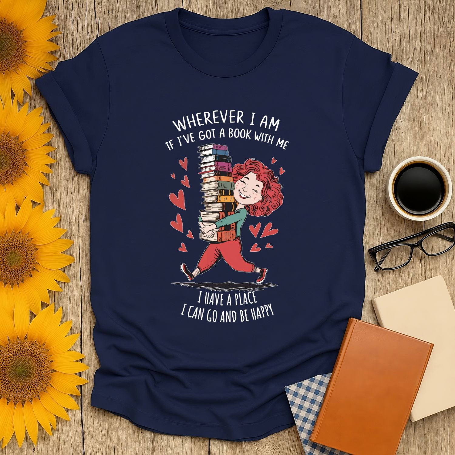 Book lover shirt featuring a cheerful person carrying a stack of books with hearts, perfect for cozy readers who enjoy cats, coffee, or tea.