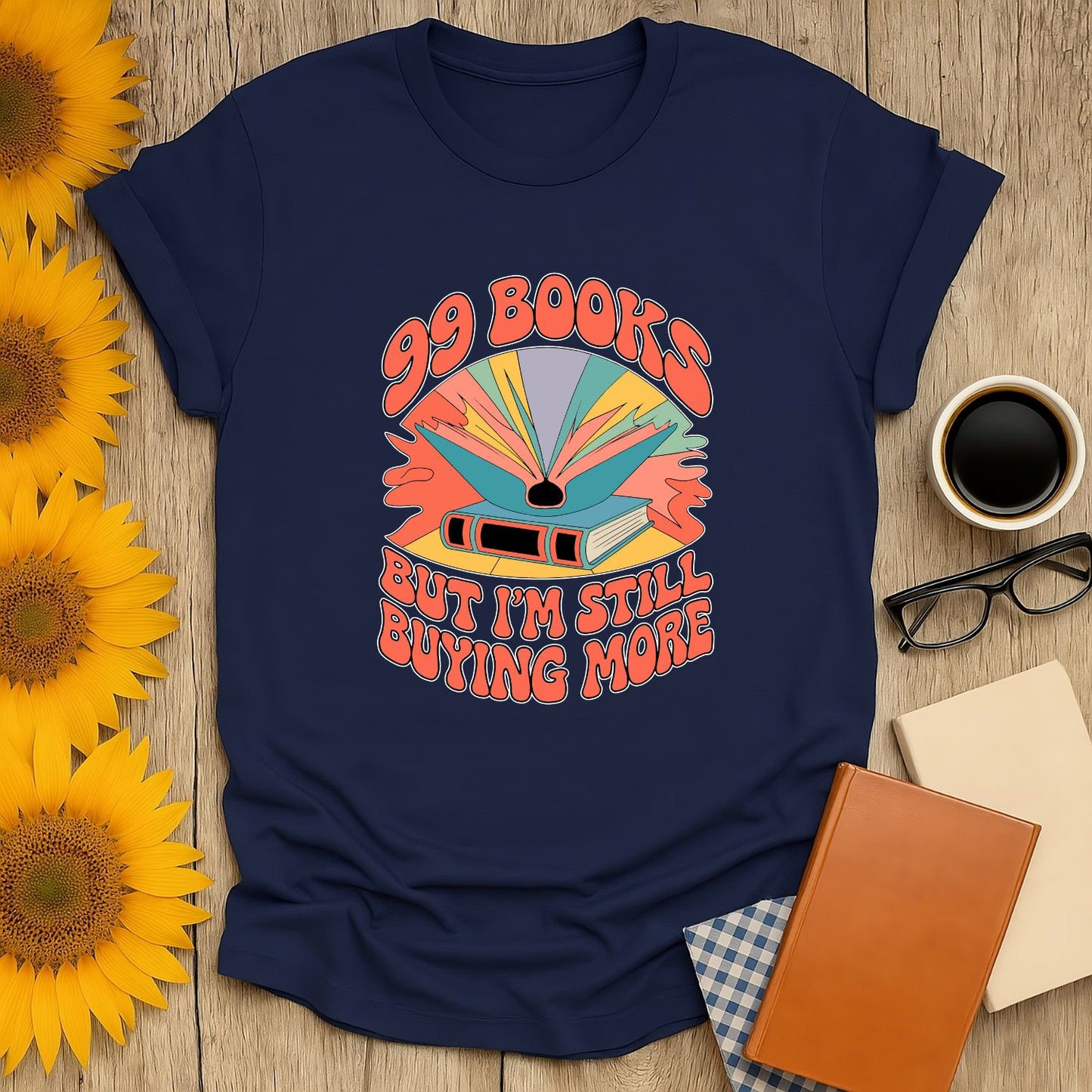 Navy unisex shirt featuring ‘99 Books but I’m Still Buying More’ design, perfect for cat, coffee, or tea-loving bookworms.