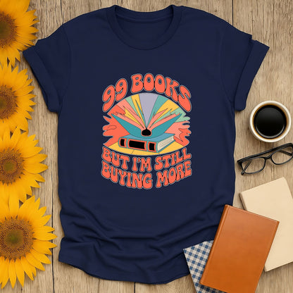 Navy unisex shirt featuring ‘99 Books but I’m Still Buying More’ design, perfect for cat, coffee, or tea-loving bookworms.