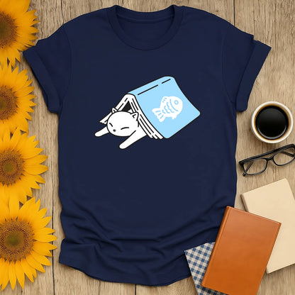 Cozy Cat Bookmark T-Shirt featuring a sleepy cat peeking from a book with a fish; perfect for book lovers and cat enthusiasts.