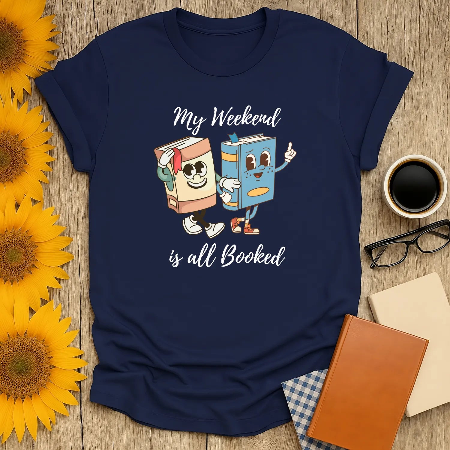 Cozy book lover shirt with playful cartoon books and text 'My Weekend is all Booked'—perfect for readers who adore cats, coffee, or tea.