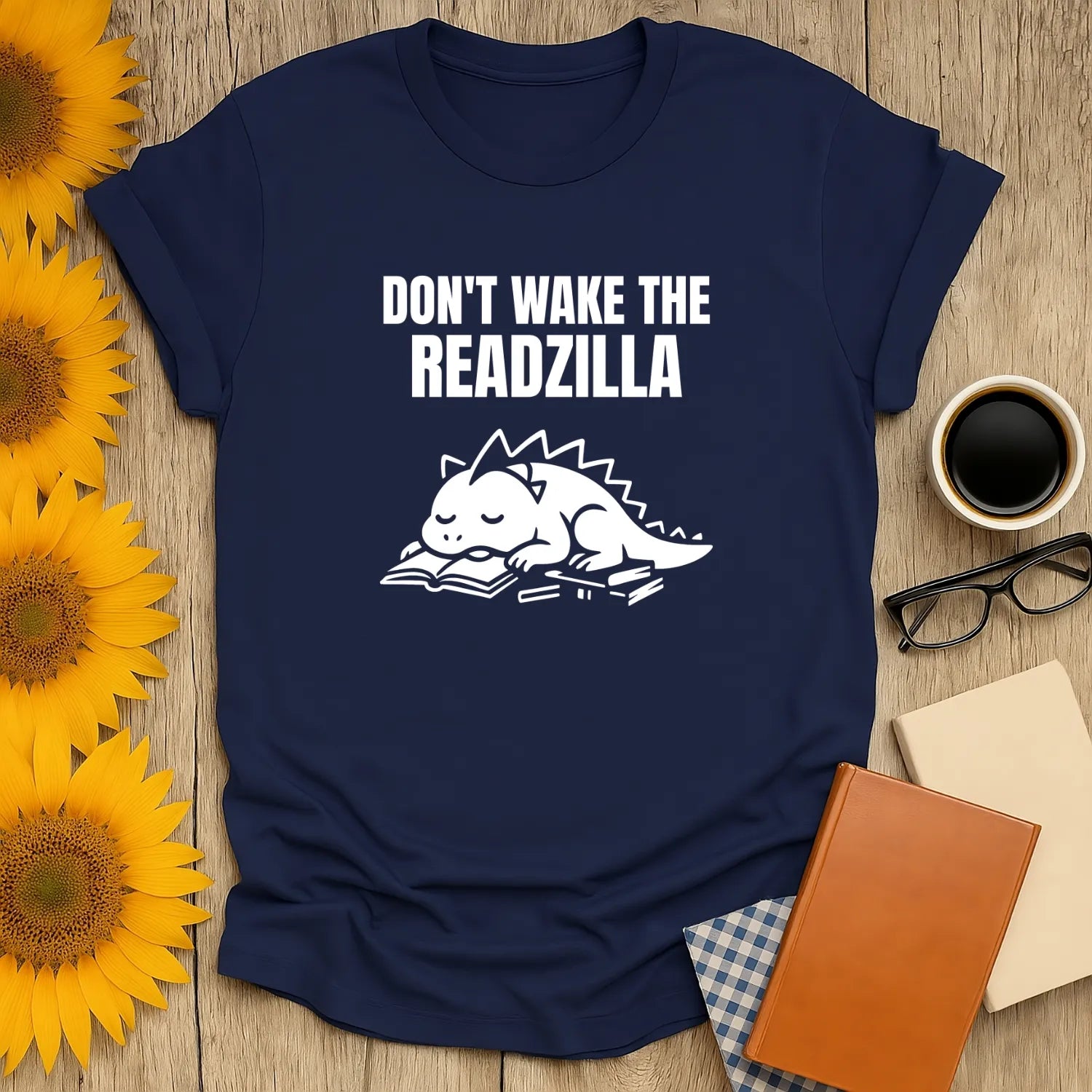 Cozy navy t-shirt featuring a sleepy Readzilla on books, with text: "Don't Wake the Readzilla" – perfect for book lovers!