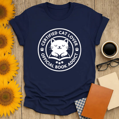 Funny Certified Cat Lover T-Shirt featuring a cute cat illustration and text declaring 'Official Book Addict'.