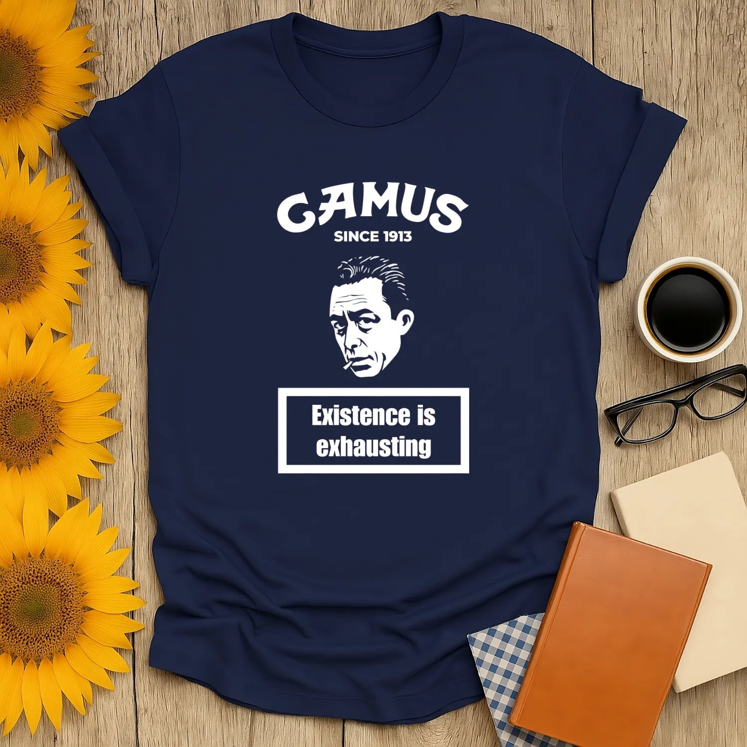 Camus Energy Level T-Shirt featuring a portrait of Camus with 'Existence is exhausting' text. Perfect for book lovers and gift seekers.