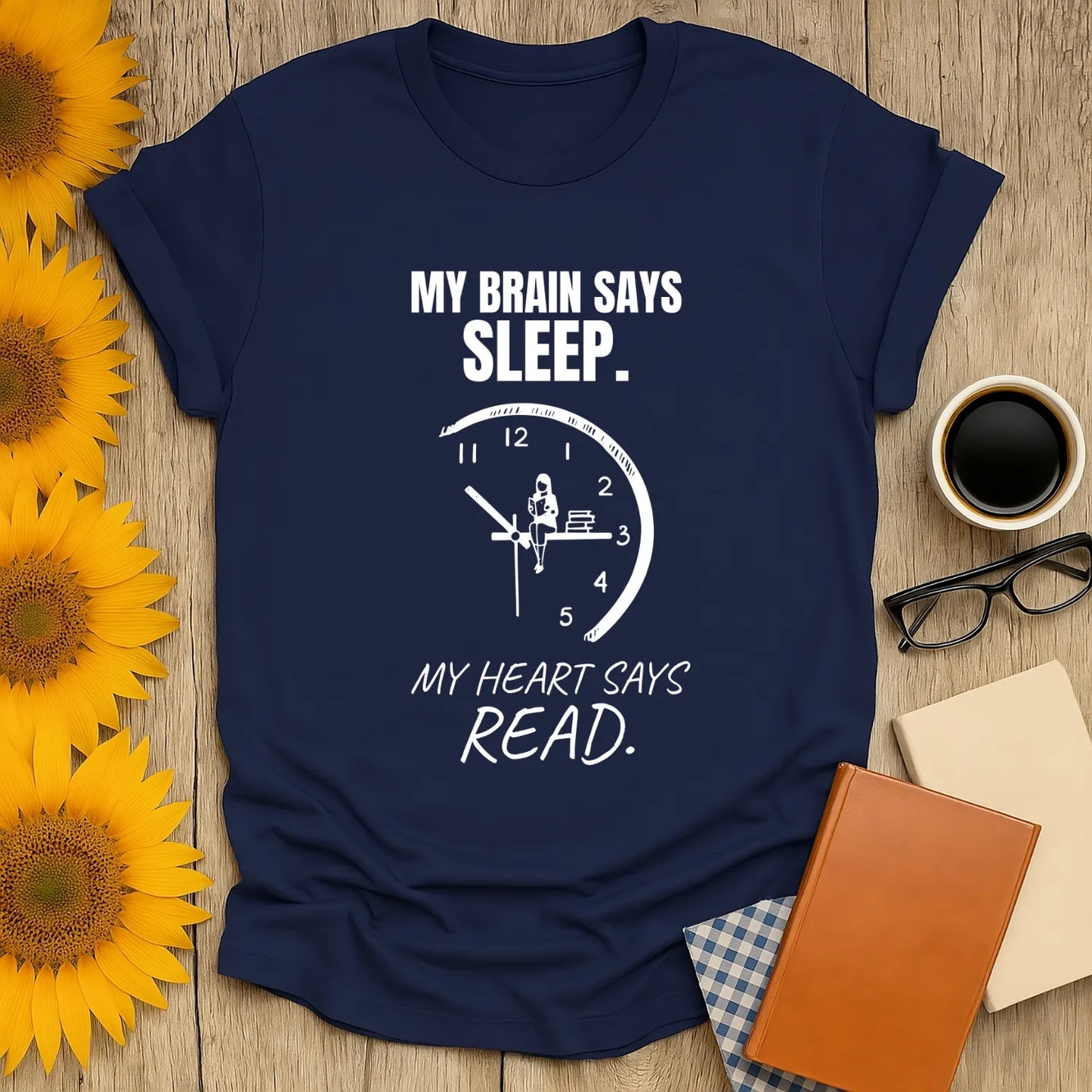 Navy blue t-shirt featuring a clock, text "My Brain Says Sleep. My Heart Says Read." Ideal funny shirt for book lovers.