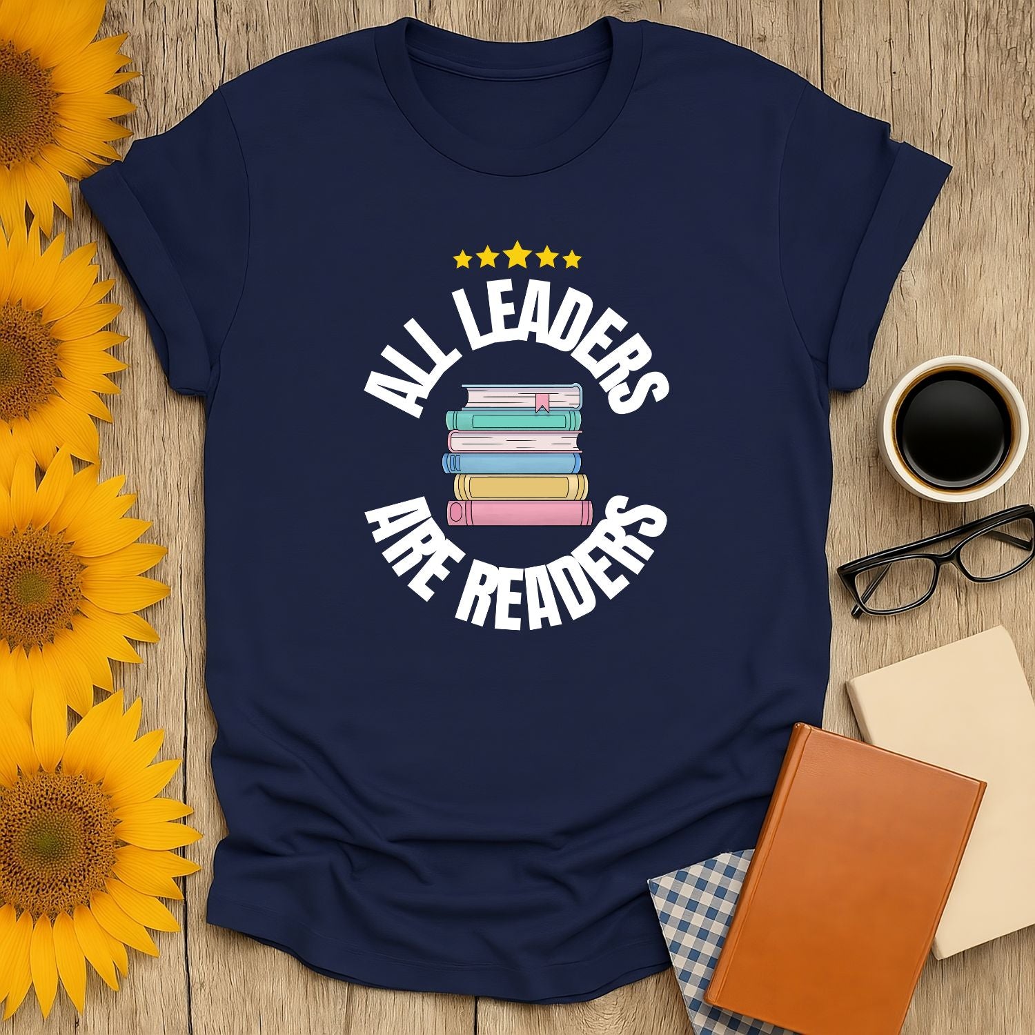 Navy blue t-shirt with 'All Leaders Are Readers' text and stacked book illustration; perfect cozy tee for book lovers.