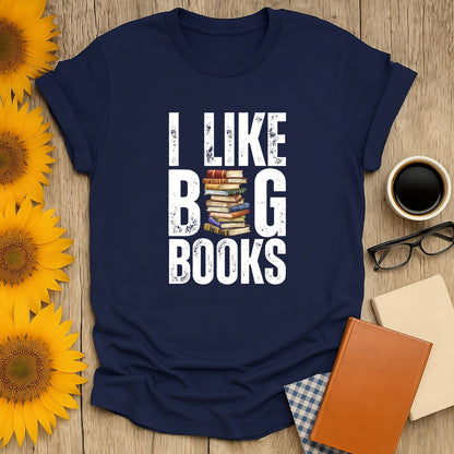 Funny reading tee saying 'I Like Big Books' with stacked books illustration, perfect cozy book shirt for cat and coffee lovers.